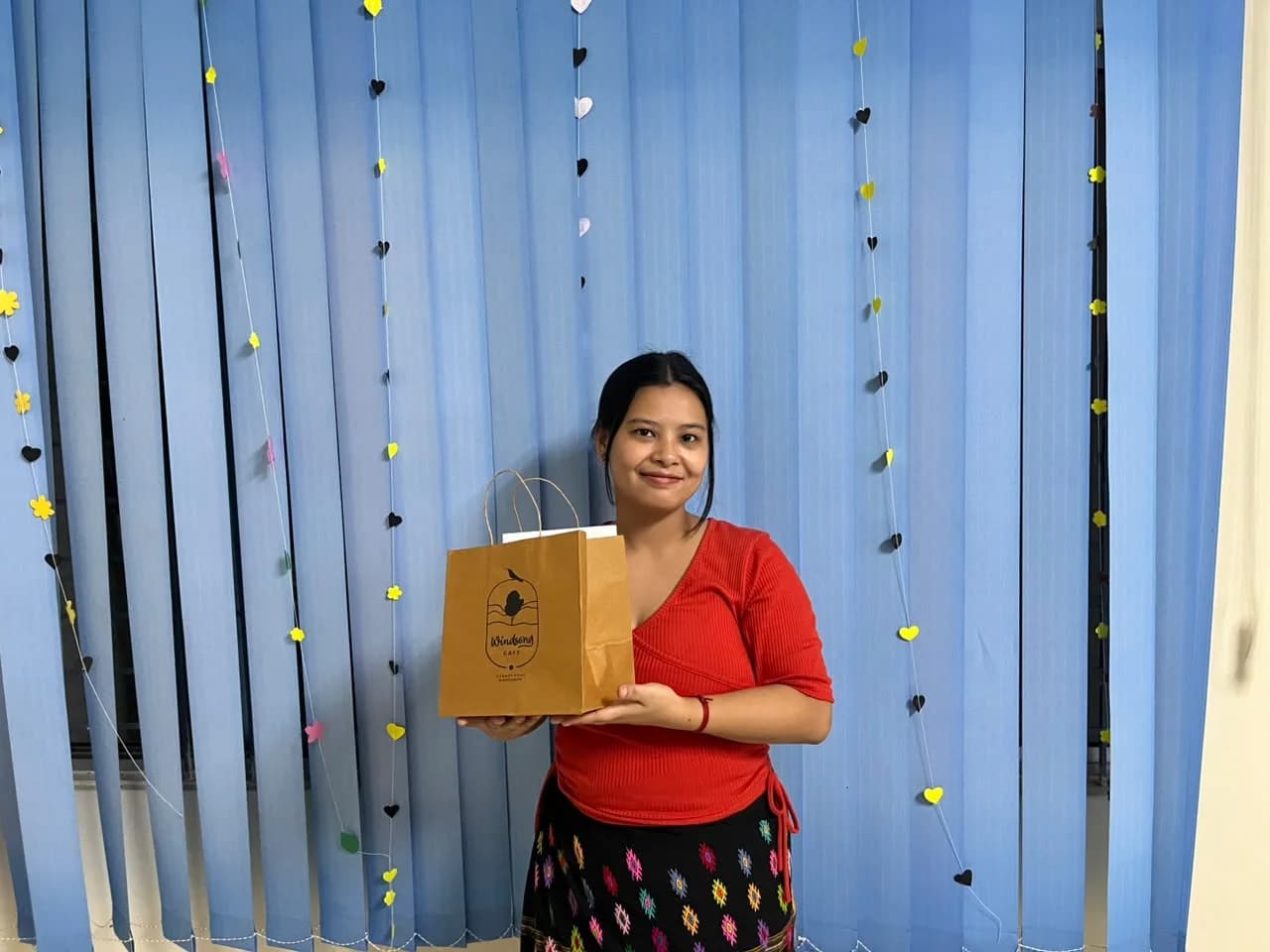 A participant holding a Windsong Café gift bag