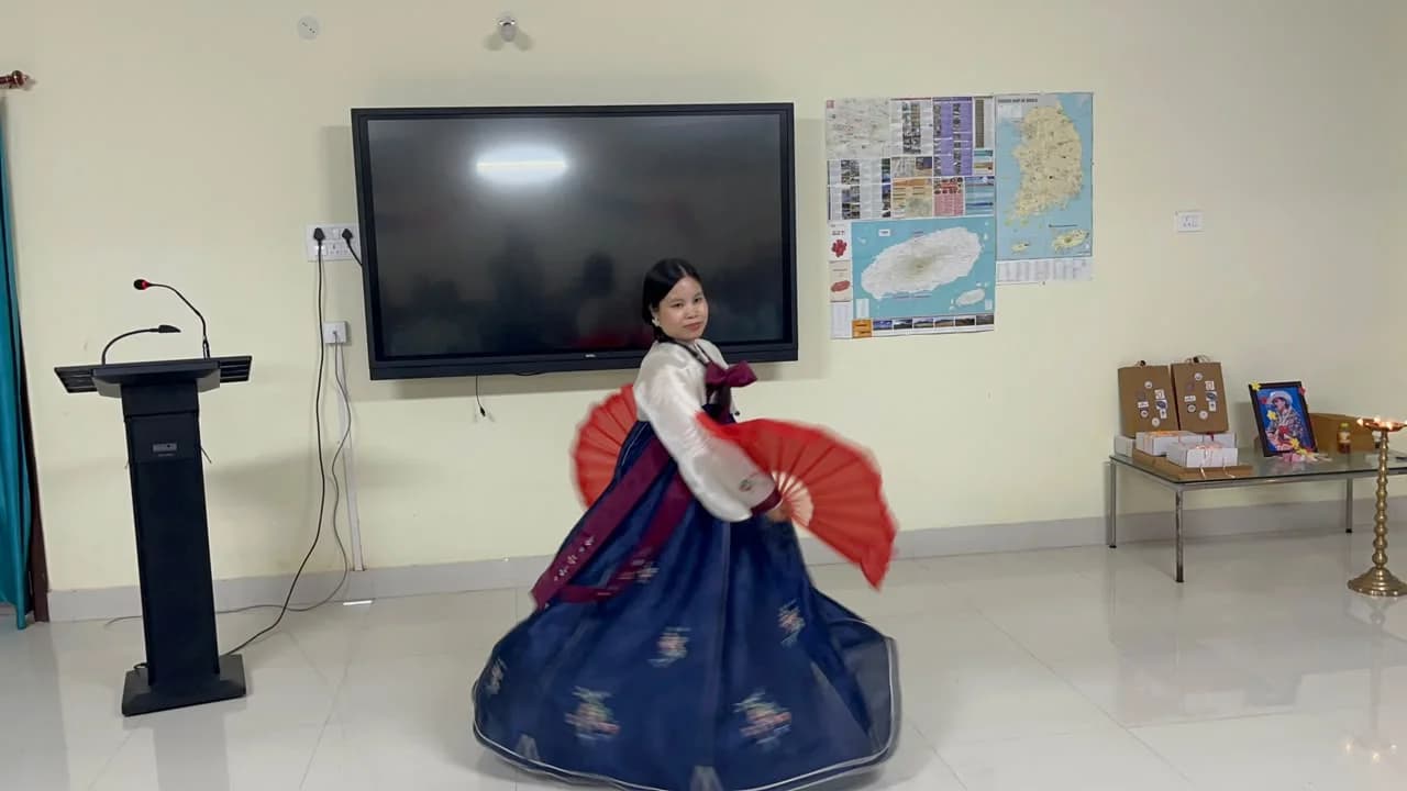 A dancer in hanbok spinning with red fans
